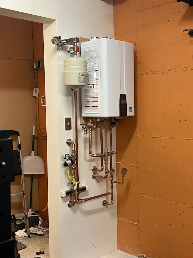 Plumbing technician inspecting water heater connections in Centerville